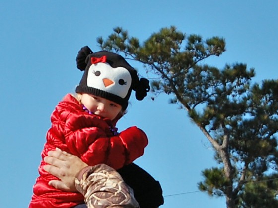 dad in camo jacket holds stylishly bundled toddler aloft